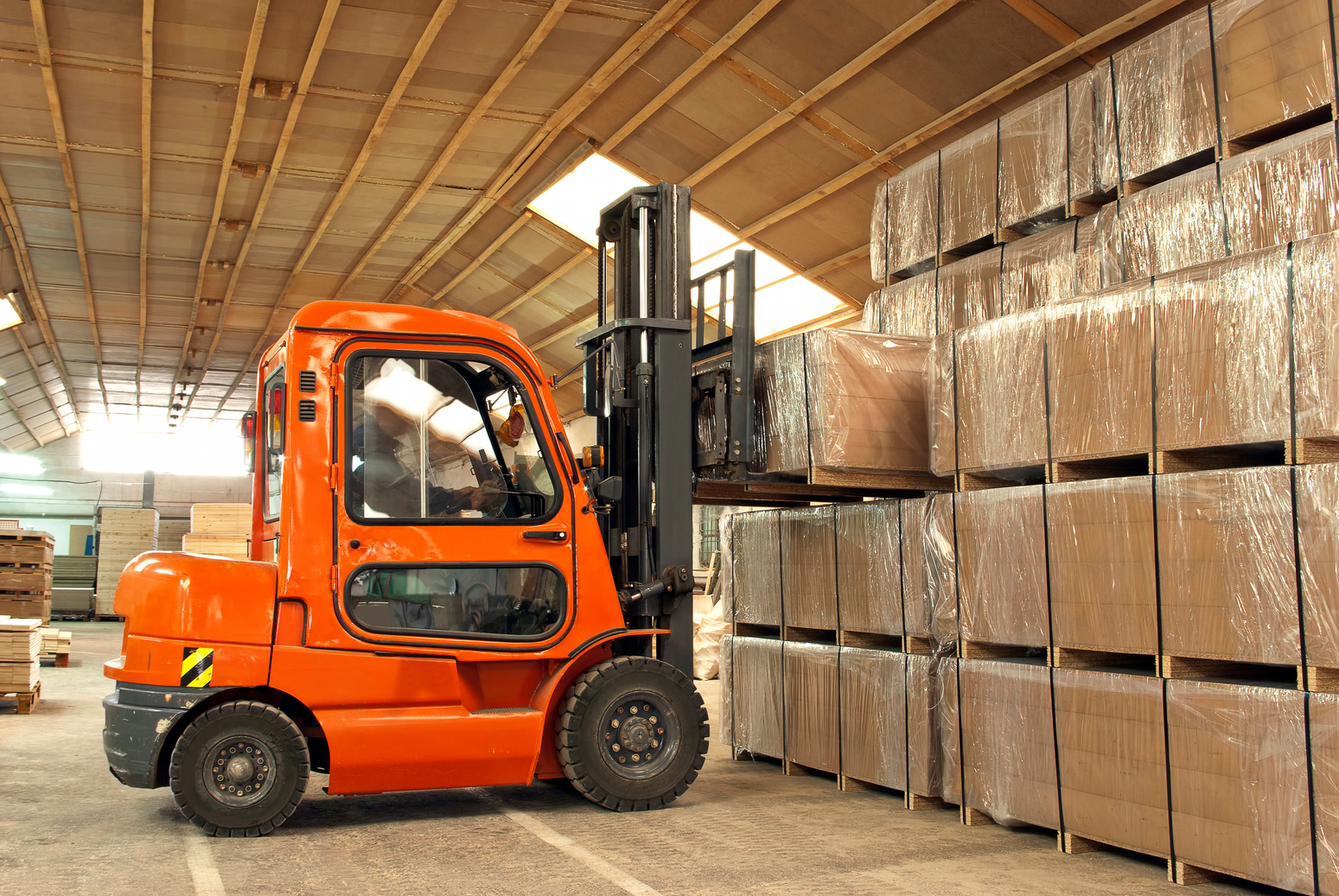 Forklift operator loading boxes in warehouse